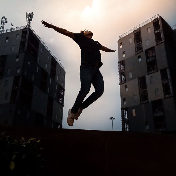 Silhouette of a man stretching against a sunrise, symbolizing balance in life.